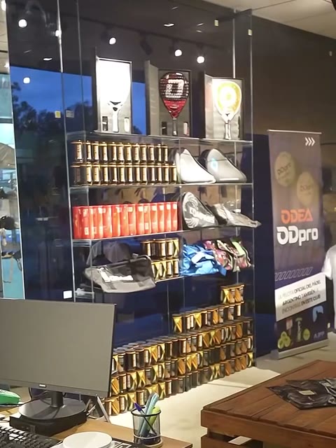 Vitrina de la tienda con paletas, tubos de pelotas y zapatillas.