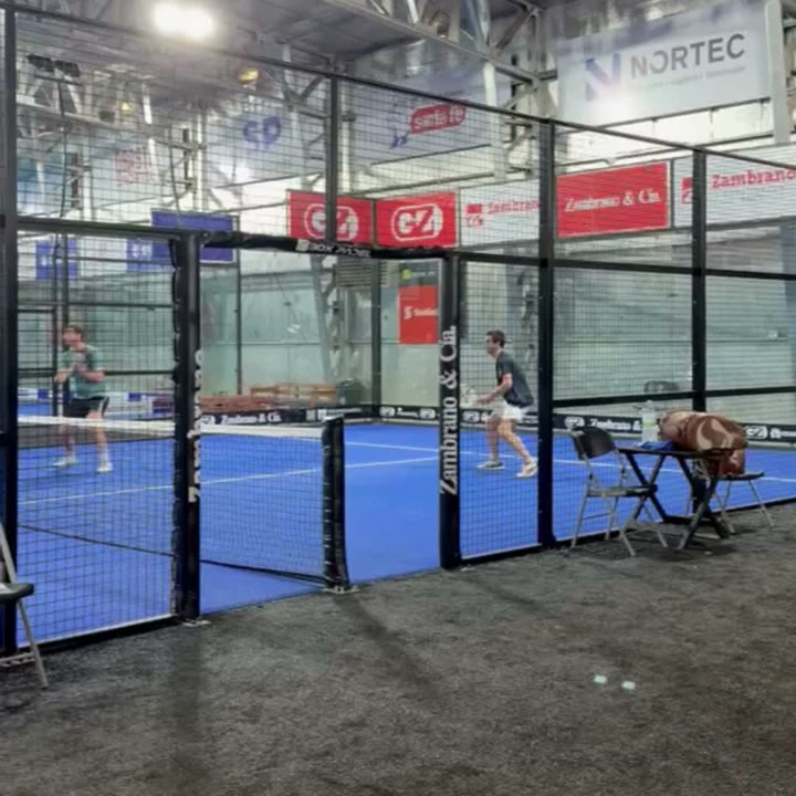 Canchas de cristal y césped azul bajo el techo del galpón.